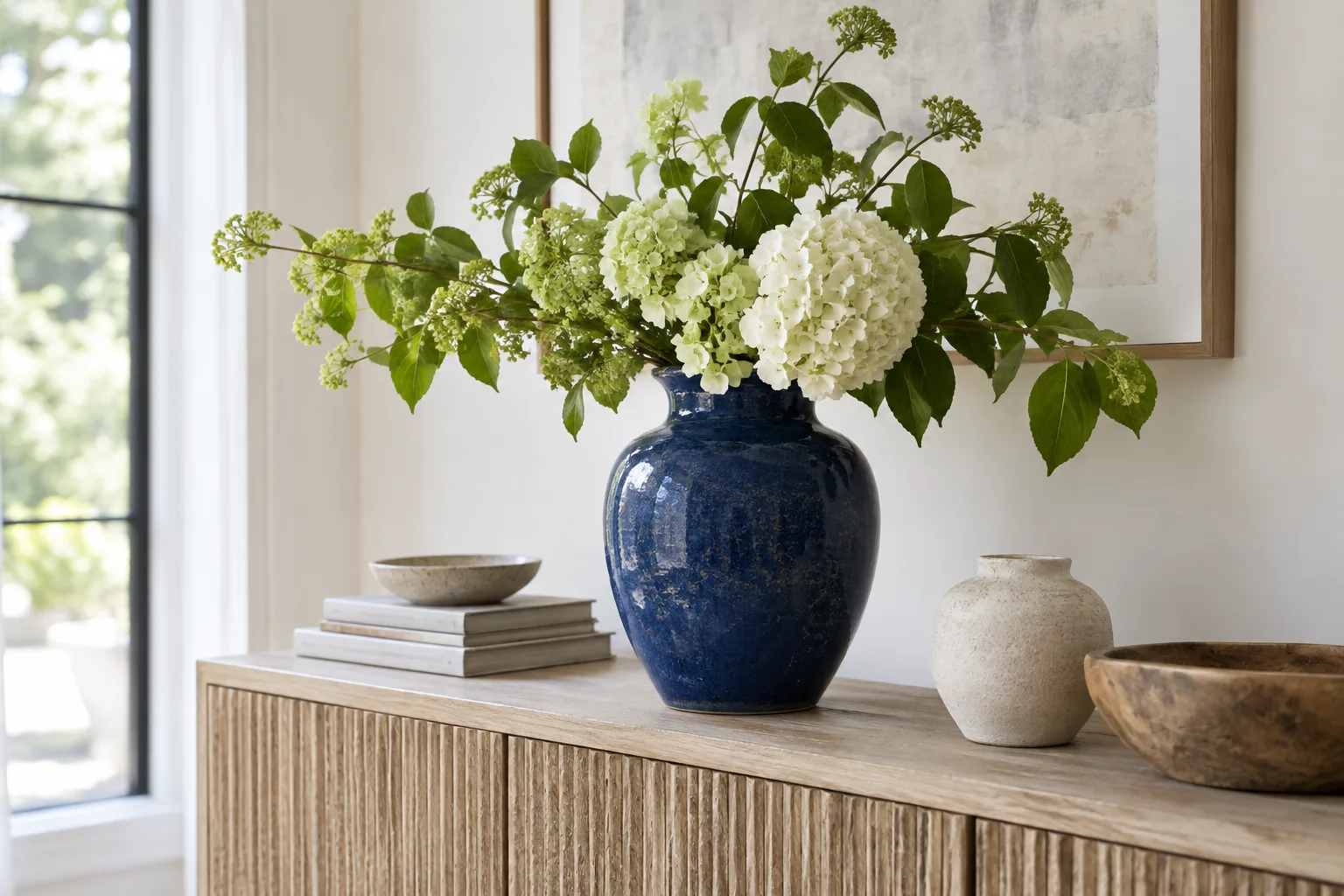 Deep-blue ceramic vase on a sideboard in a bright, naturally lit room